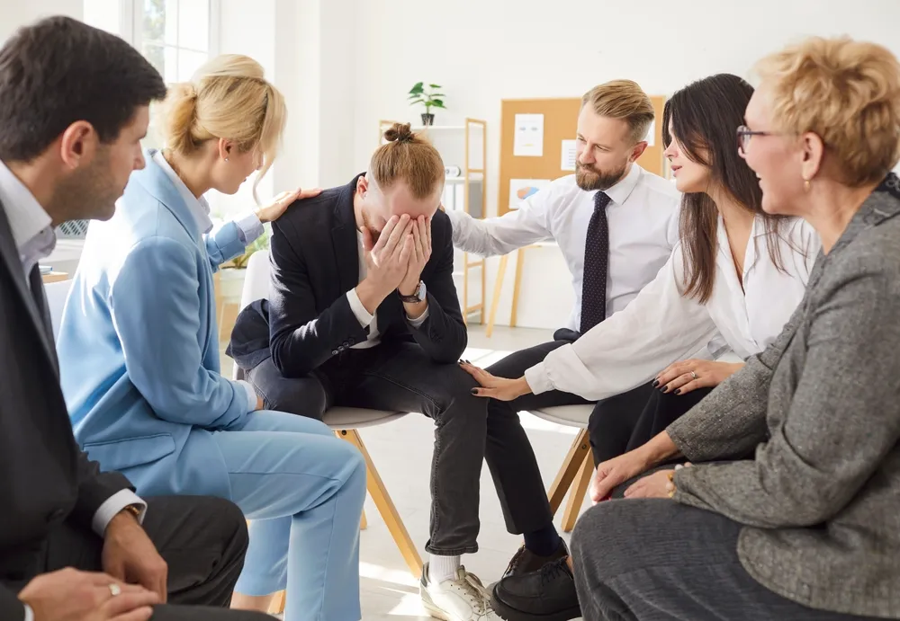 Adults sitting together in a supportive group discussion about ADHD and mental health