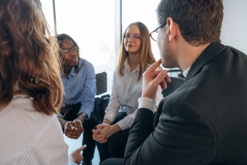 Adults sitting together in a supportive group discussion about ADHD and mental health