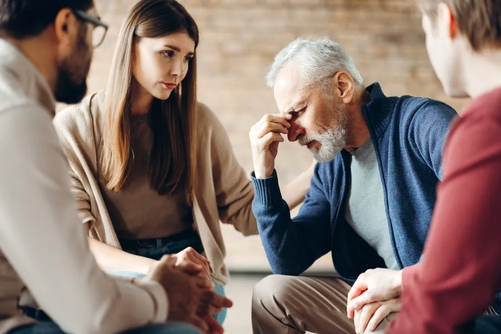Adults sitting together in a supportive group discussion about ADHD and mental health