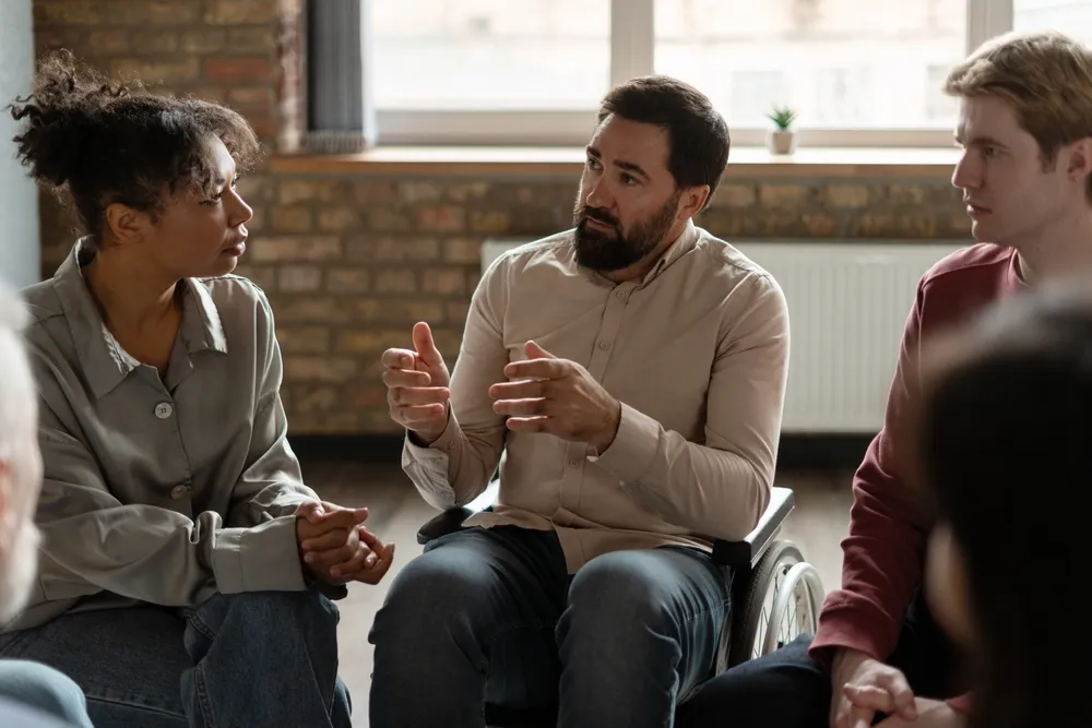 Small support group sitting together in a calm and private mental health setting