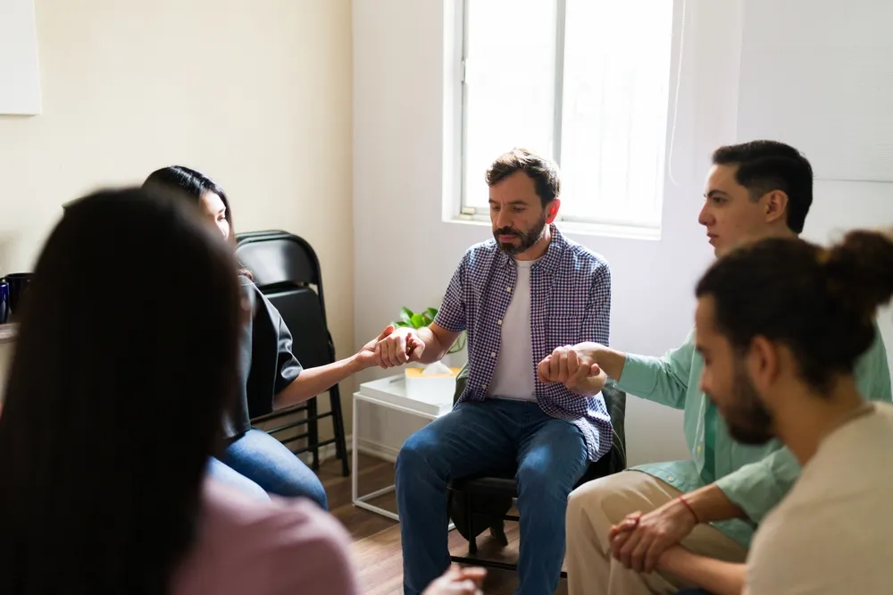 Small support group sitting together in a calm and private mental health setting